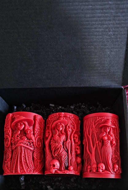 Wisdomkeeper, Bonekeeper and Grovekeeper red candles together in a black box with black paper shred.