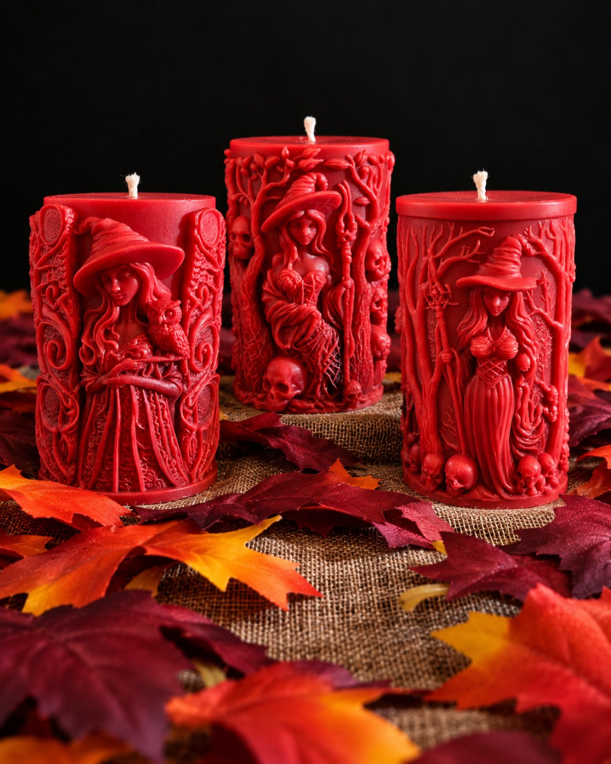 Keeper Set featuring red Wisdomkeeper, Bonekeeper, and Grovekeeper sculpted witch candles displayed among autumn leaves.